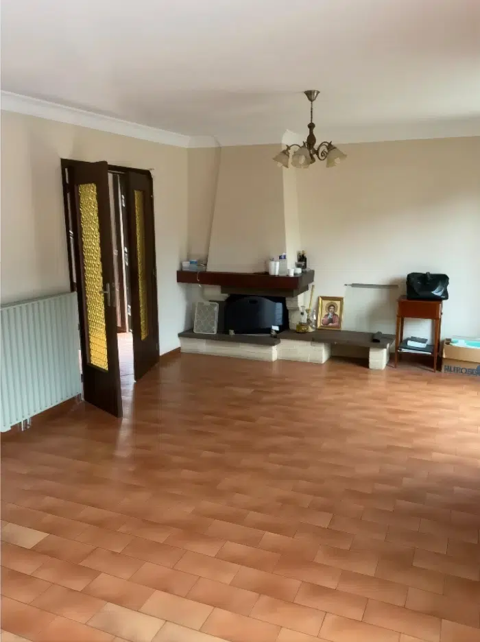 Salon vide avec parquet et cheminée