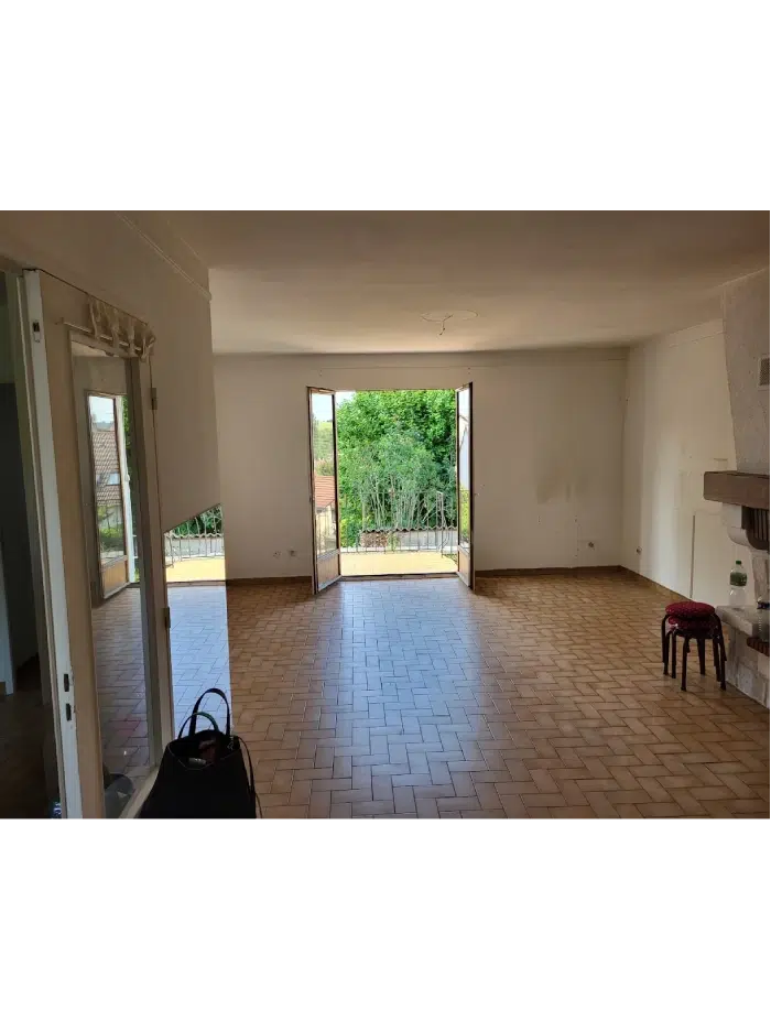 Salle vide avec portes ouvertes sur jardin